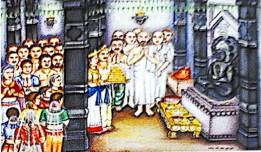 Devotees gathered inside a temple for a ritual; priests in white perform puja before a black idol, while others offer golden trays.